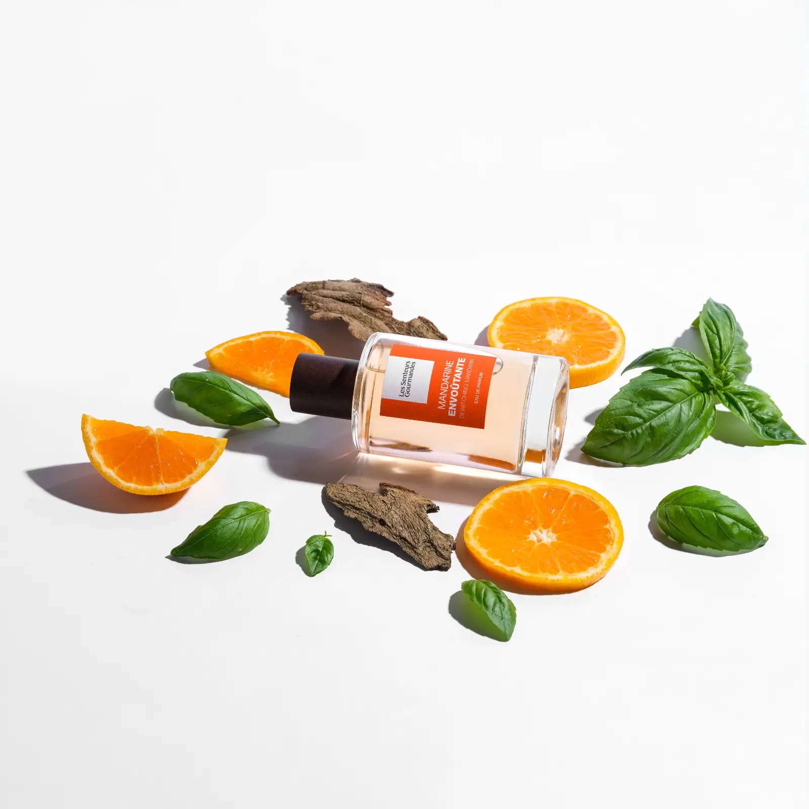MANDARINE ENVOÛTANTE, un parfum hespéridé aromatique qui capture la vivacité de la mandarine et la fraîcheur du basilic dans un sillage boisé sec pour une touche sophistiquée.