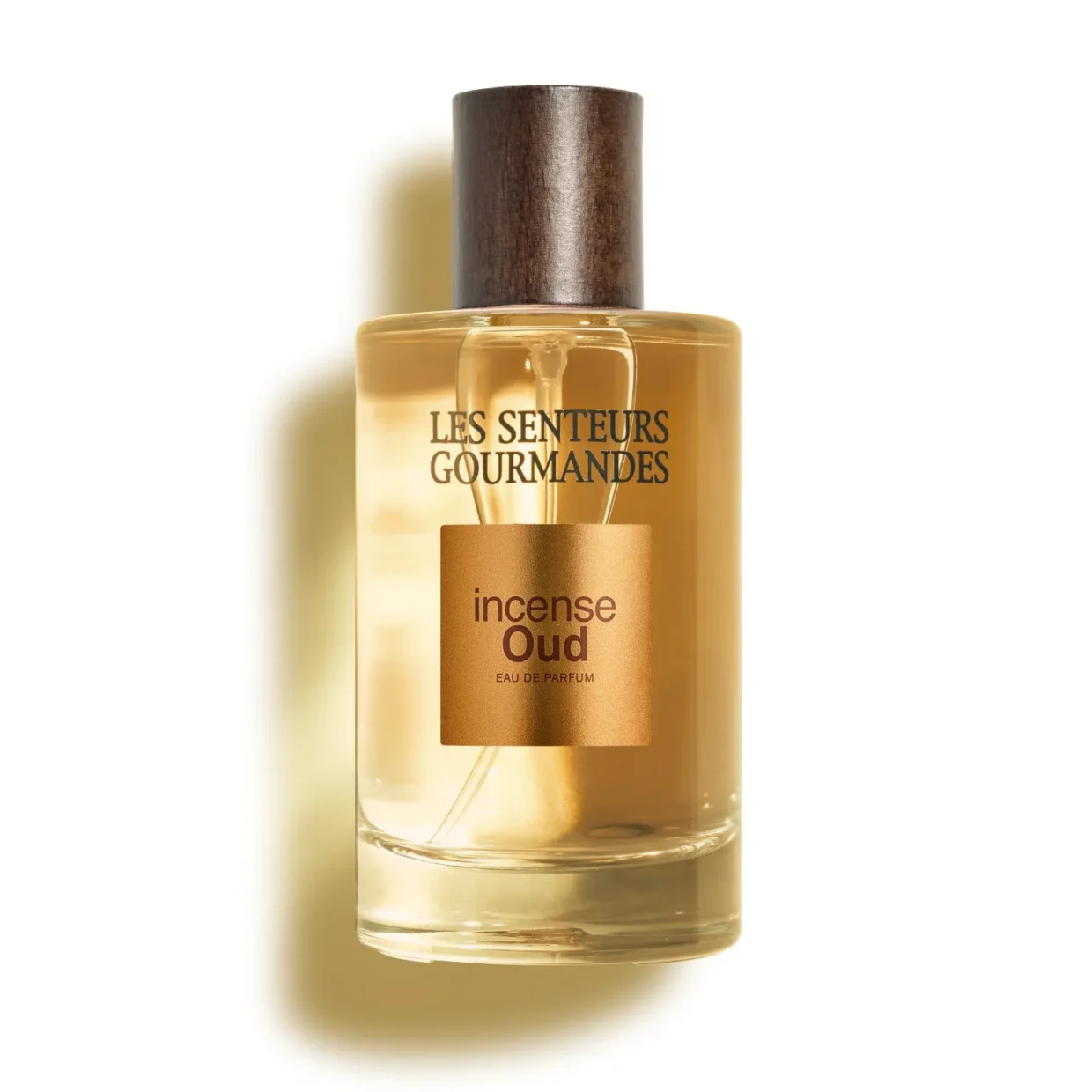 Grand flacon 100ml d'Eau de Parfum Incense Oud de la marque Les Senteurs Gourmandes, bouteille en verre transparent mettant en valeur un jus ambré, avec son bouchon cylindrique en bois foncé et une étiquette carrée bronze aux reflets métallisés au centre.