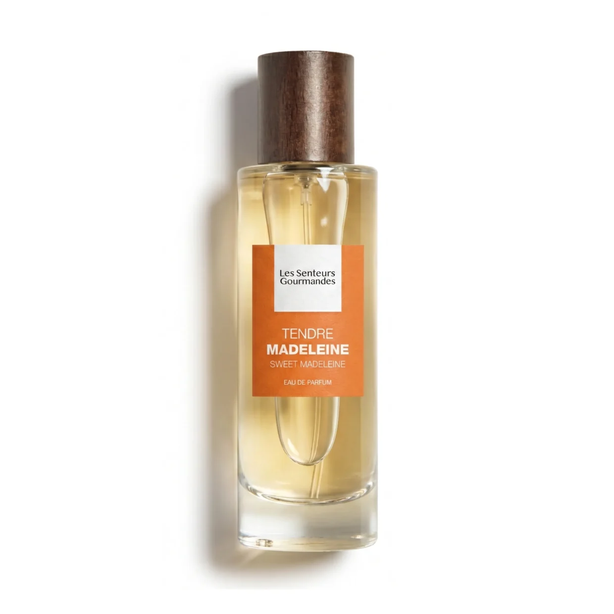 Flacon 30ml d'Eau de Parfum Tendre Madeleine de la marque Les Senteurs Gourmandes, petite bouteille en verre transparent laissant apparaître un jus ambré, avec son bouchon cylindrique en bois foncé et une étiquette orange abricot au centre.