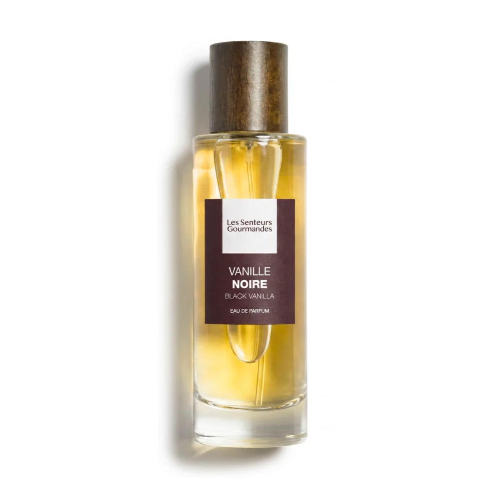 Flacon 30ml d'Eau de Parfum Vanille Noire de la marque Les Senteurs Gourmandes, petite bouteille en verre transparent avec son bouchon cylindrique en bois foncé et une étiquette marron foncé aux nuances prune au centre.